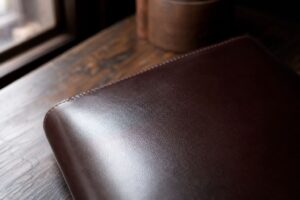 ガラスのようなつやを帯びた焦げ茶のコードバン革のクローズアップ